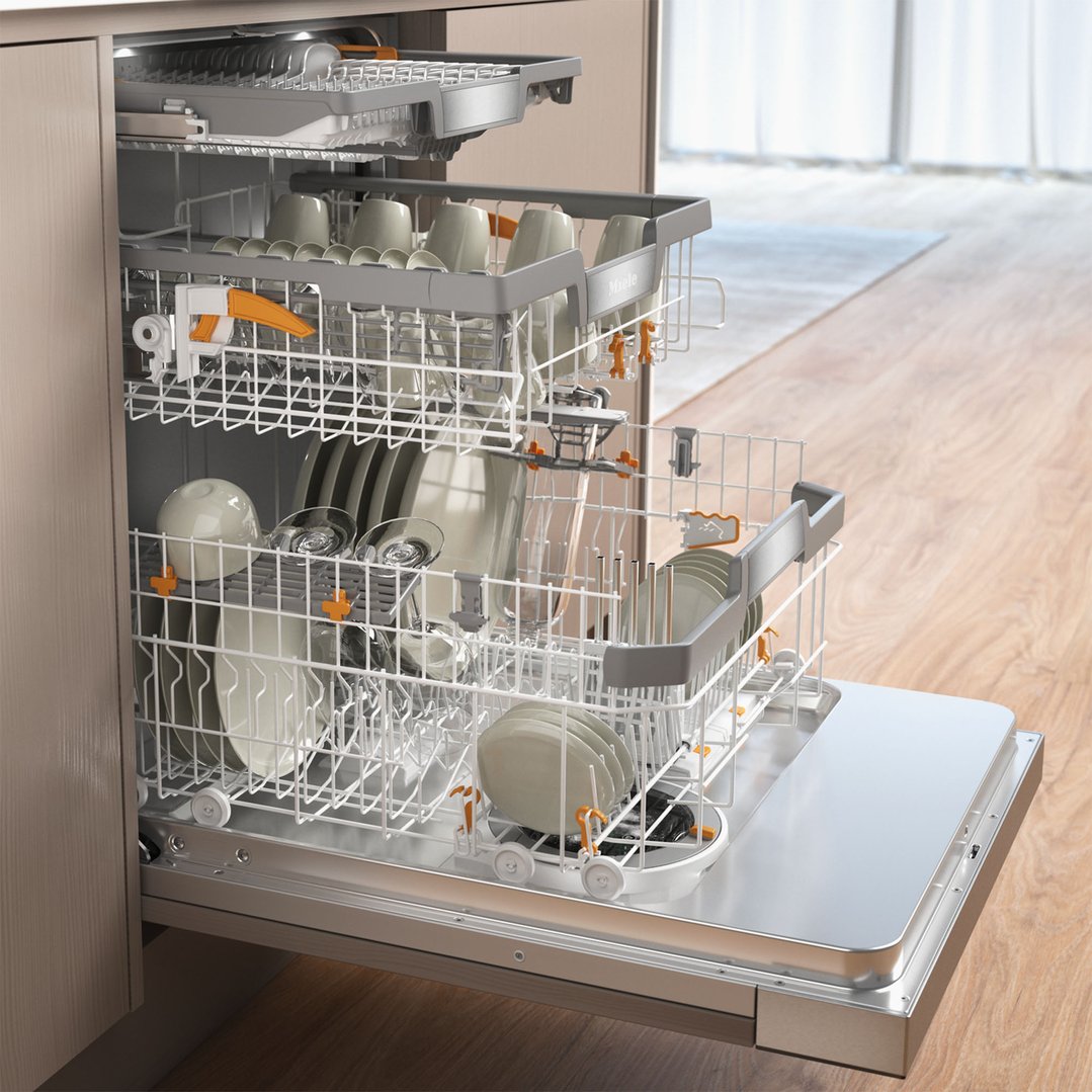 Open Miele dishwasher with dishes inside, in a kitchen setting