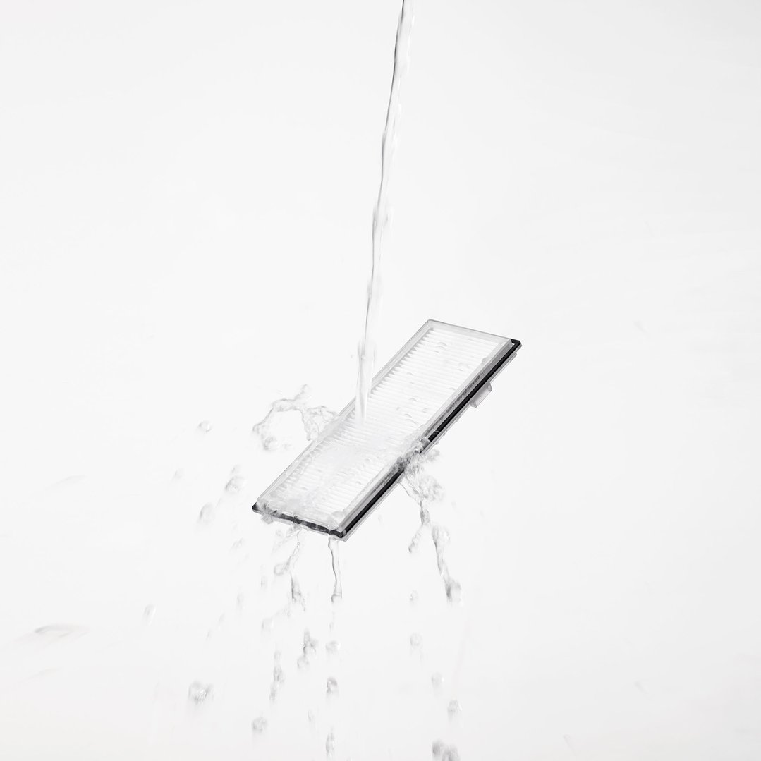 Water being poured over a white washable filter, creating splashes