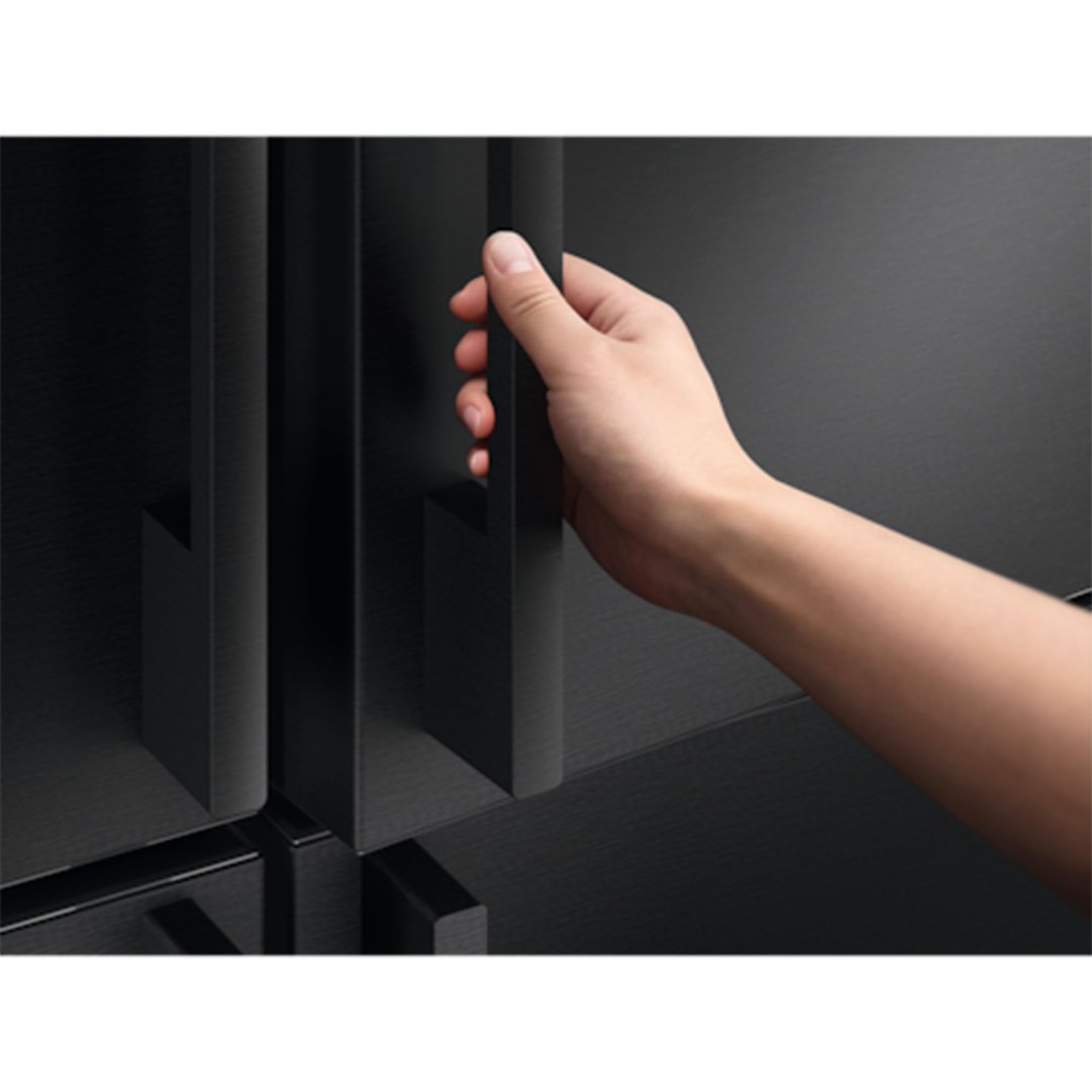 Hand opening the door of a black Electrolux fridge