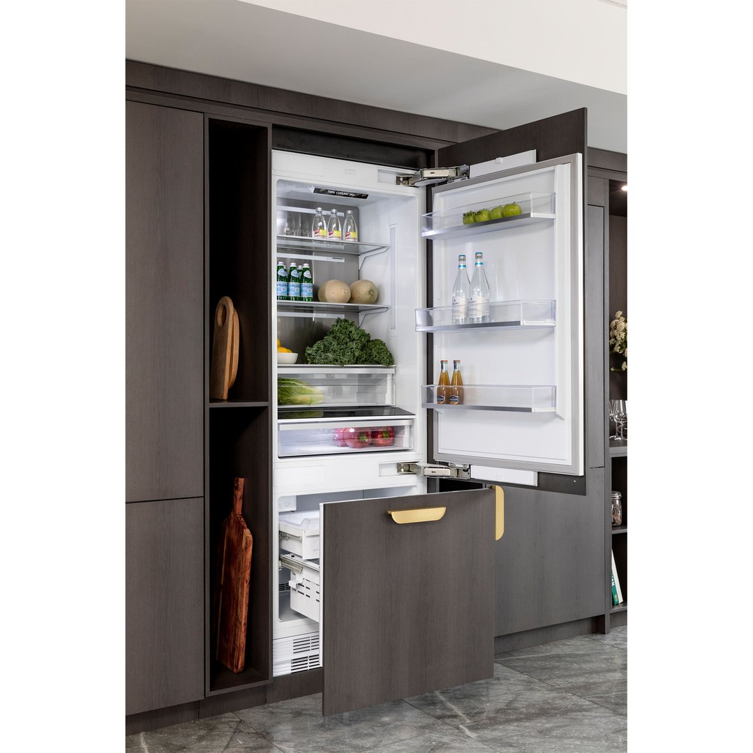 Fully integrated bottom mount fridge with doors open in a dark wood kitchen