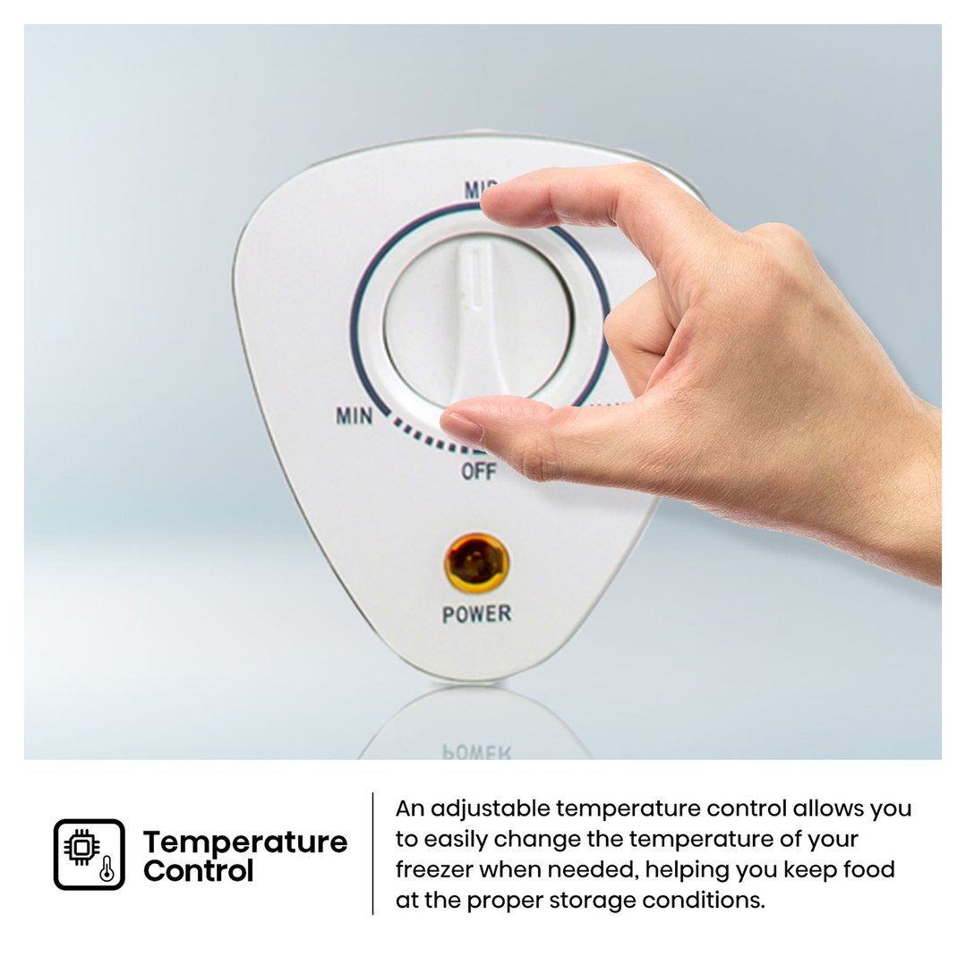 Hand adjusting the temperature control dial on a white freezer with a power light