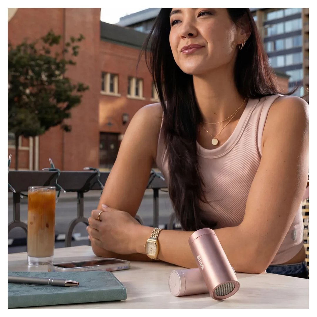 Woman sitting at an outdoor cafe with a Shark Chillpill on the table