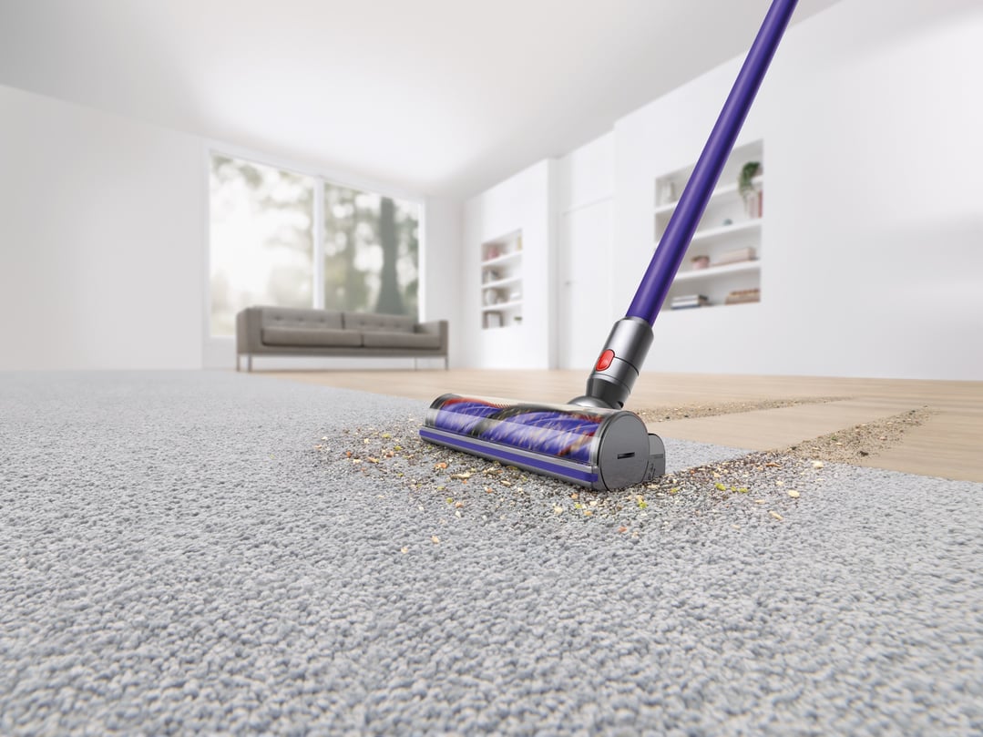Dyson V11 Stick Vacuum cleaning a carpet and hard floor in a living room
