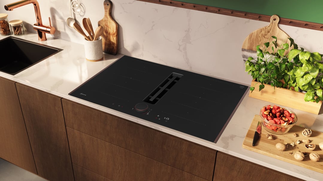 Anthracite grey induction cooktop in a modern kitchen with sink and fresh herbs