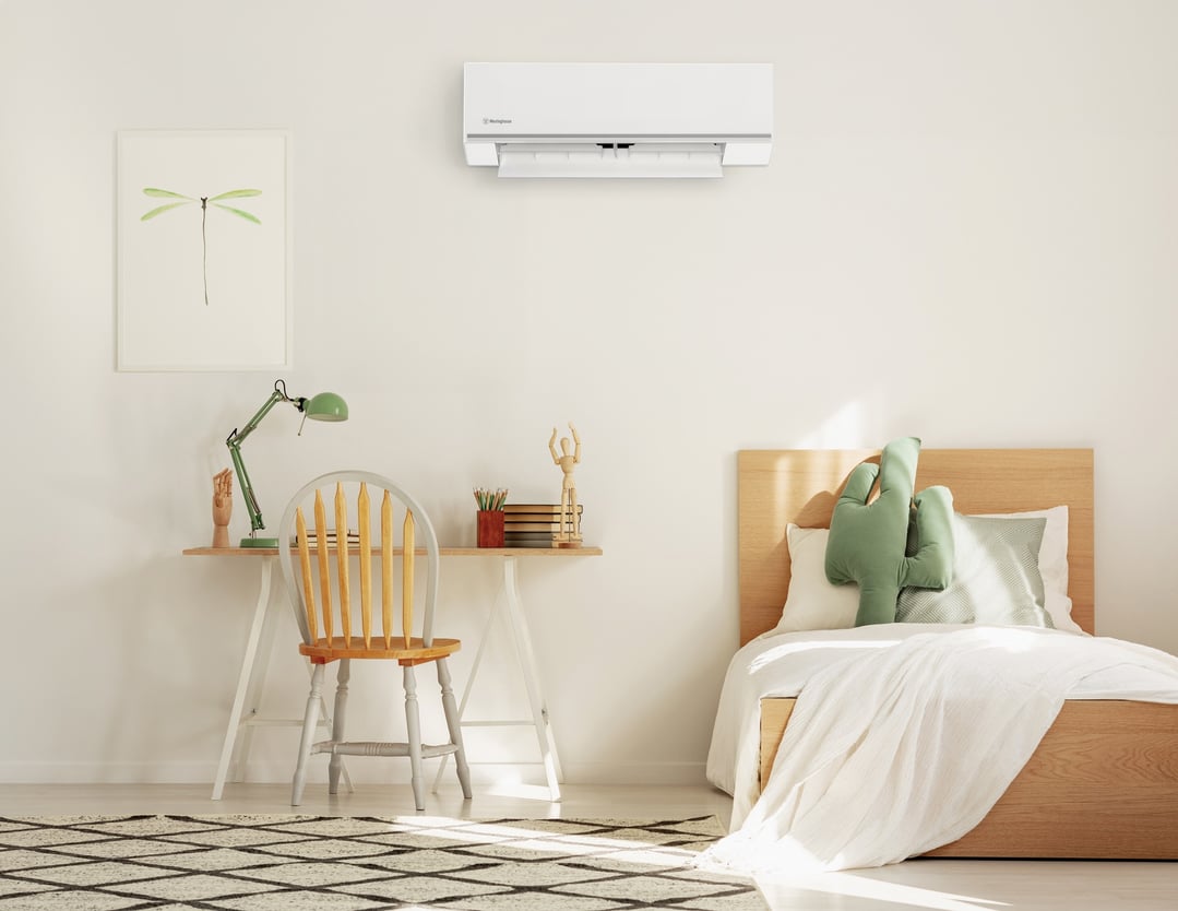 White split system air conditioner mounted on a wall in a bedroom