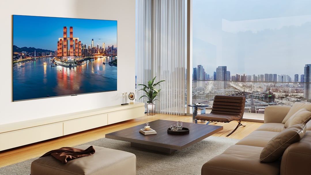A TCL TV wall-mounted in a modern living room with a city view