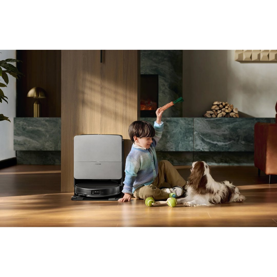 A child and dog playing near a Roborock Saros 20 robot vacuum
