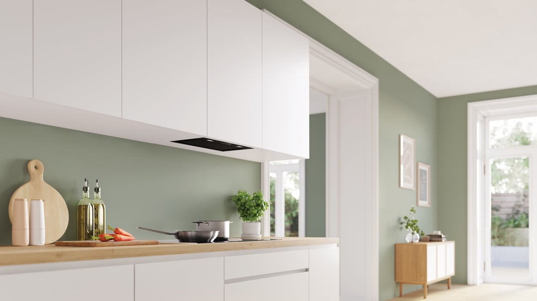 Integrated BOSCH Series 6 rangehood in a modern kitchen with green walls