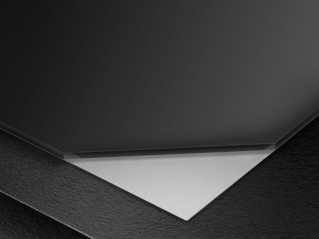 Abstract close-up of a black cooktop with a white surface underneath