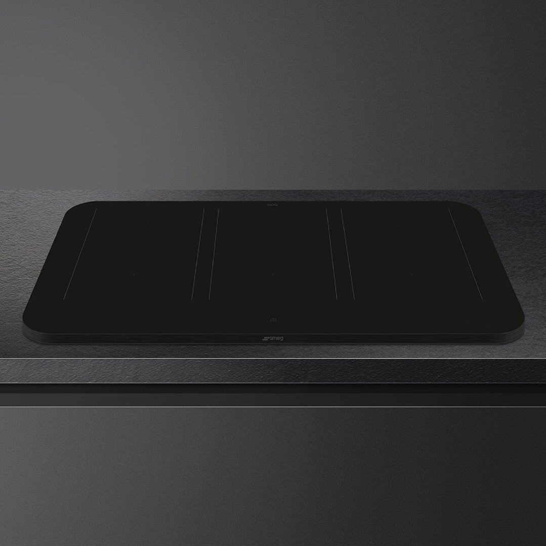 Matte black induction cooktop built into a dark grey kitchen benchtop