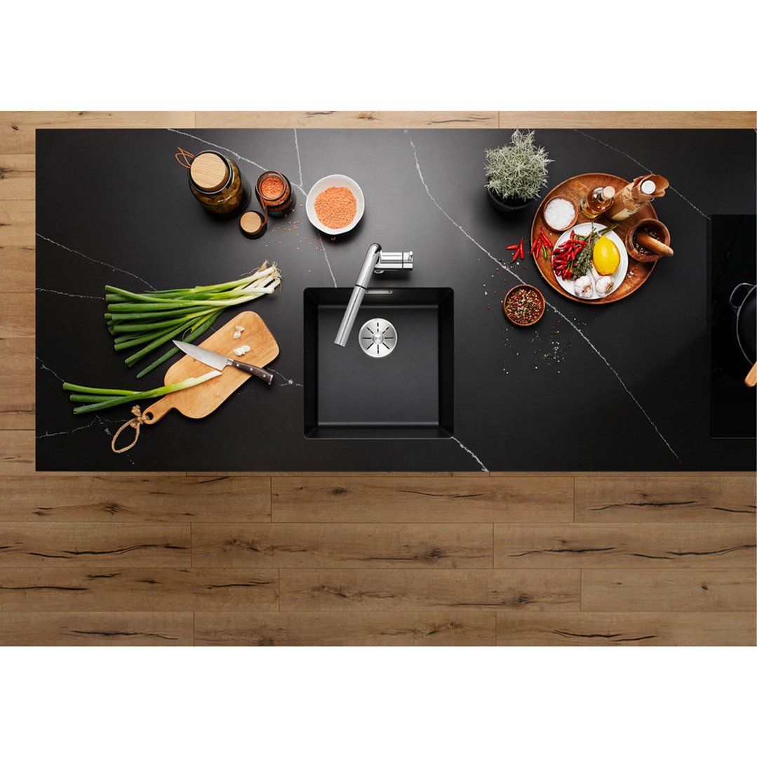 Overhead view of a black sink in a kitchen island with cooking ingredients