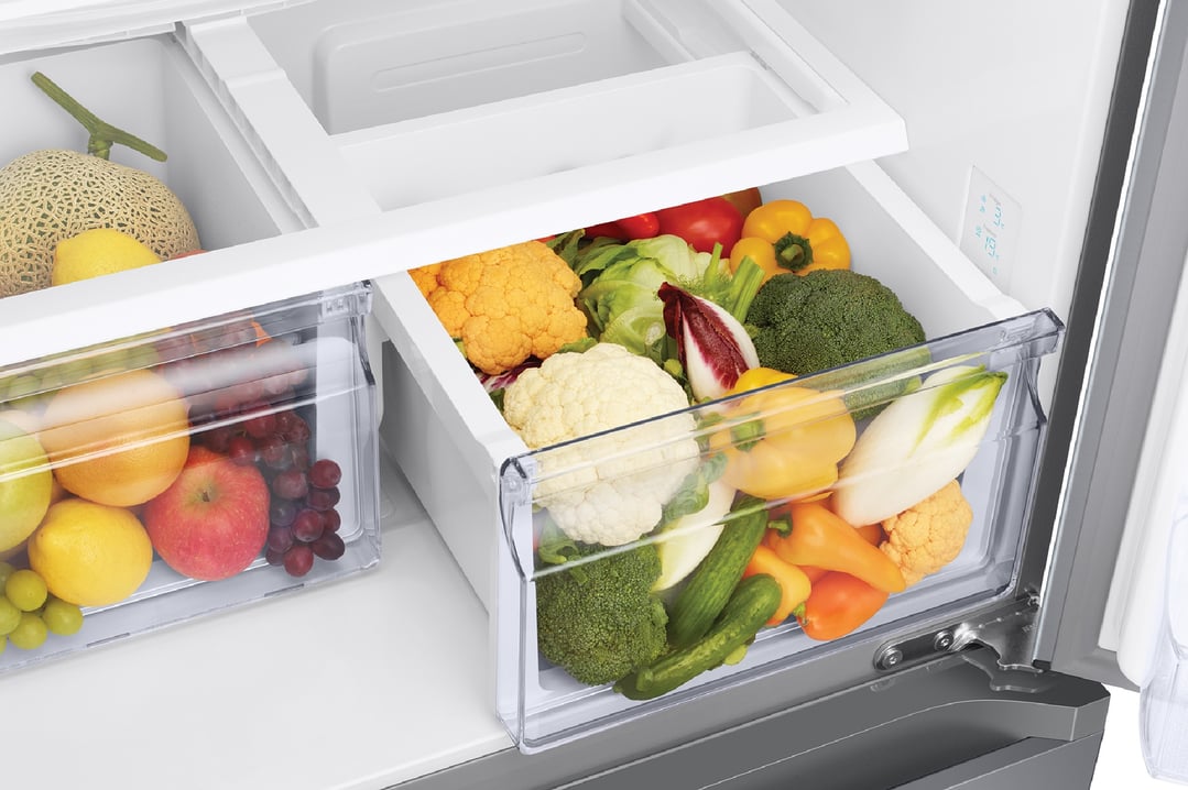 Open French door refrigerator showing fresh fruits and vegetables in drawers