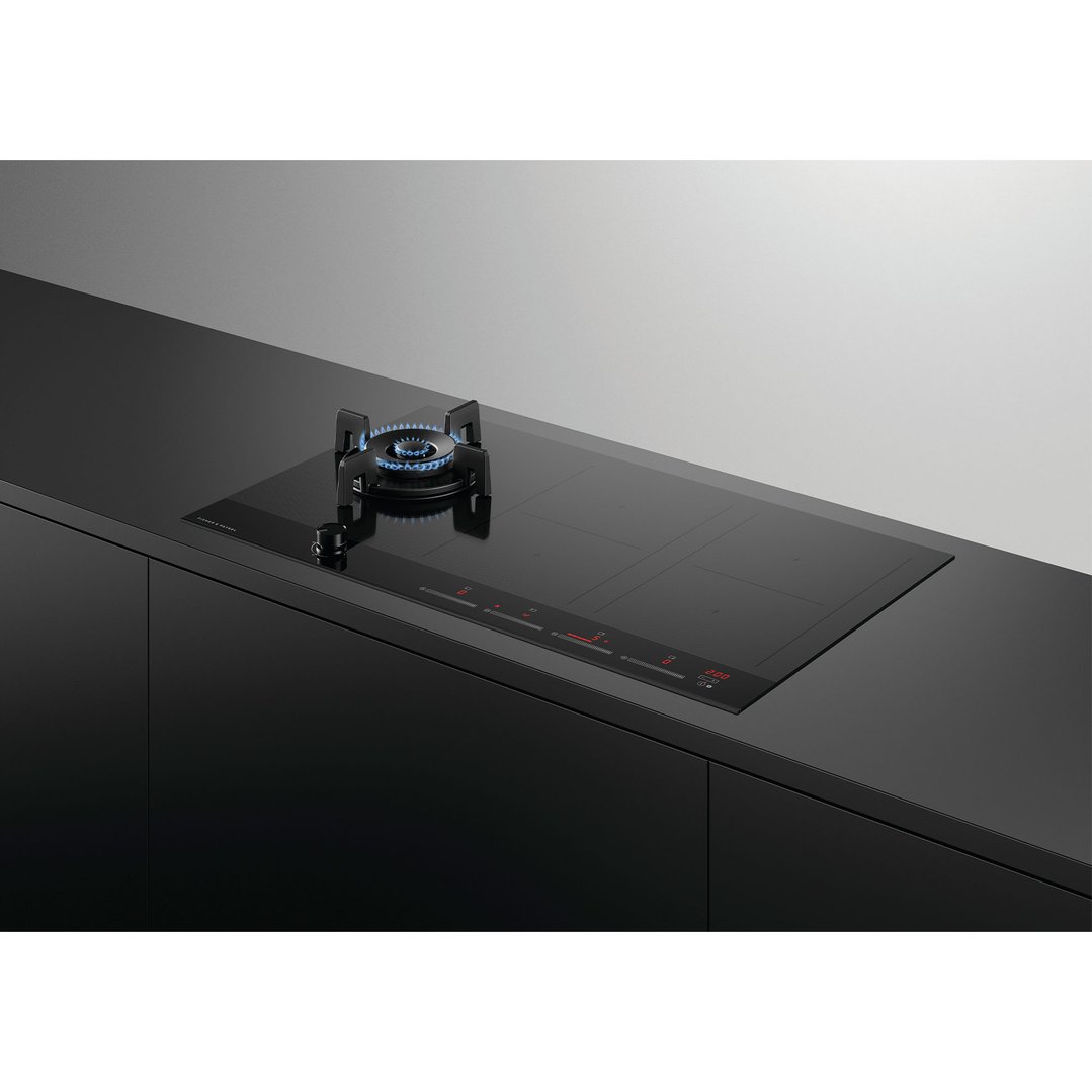 Black hybrid cooktop with gas burner and induction zones in a modern kitchen