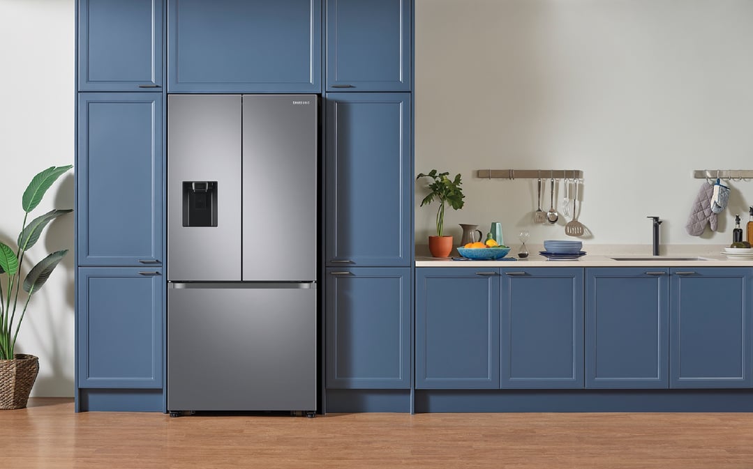 A stainless steel French door refrigerator in a blue kitchen with wooden floor