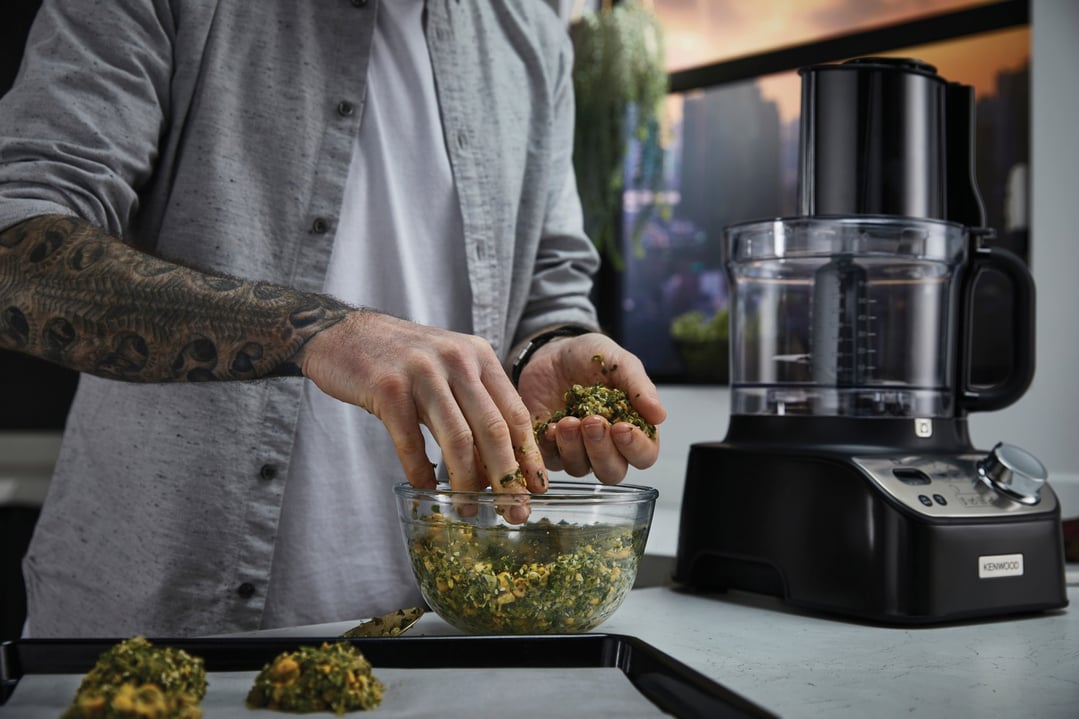 Man forming falafel balls with a KENWOOD MultiPro XL Weigh+ Food Processor nearby