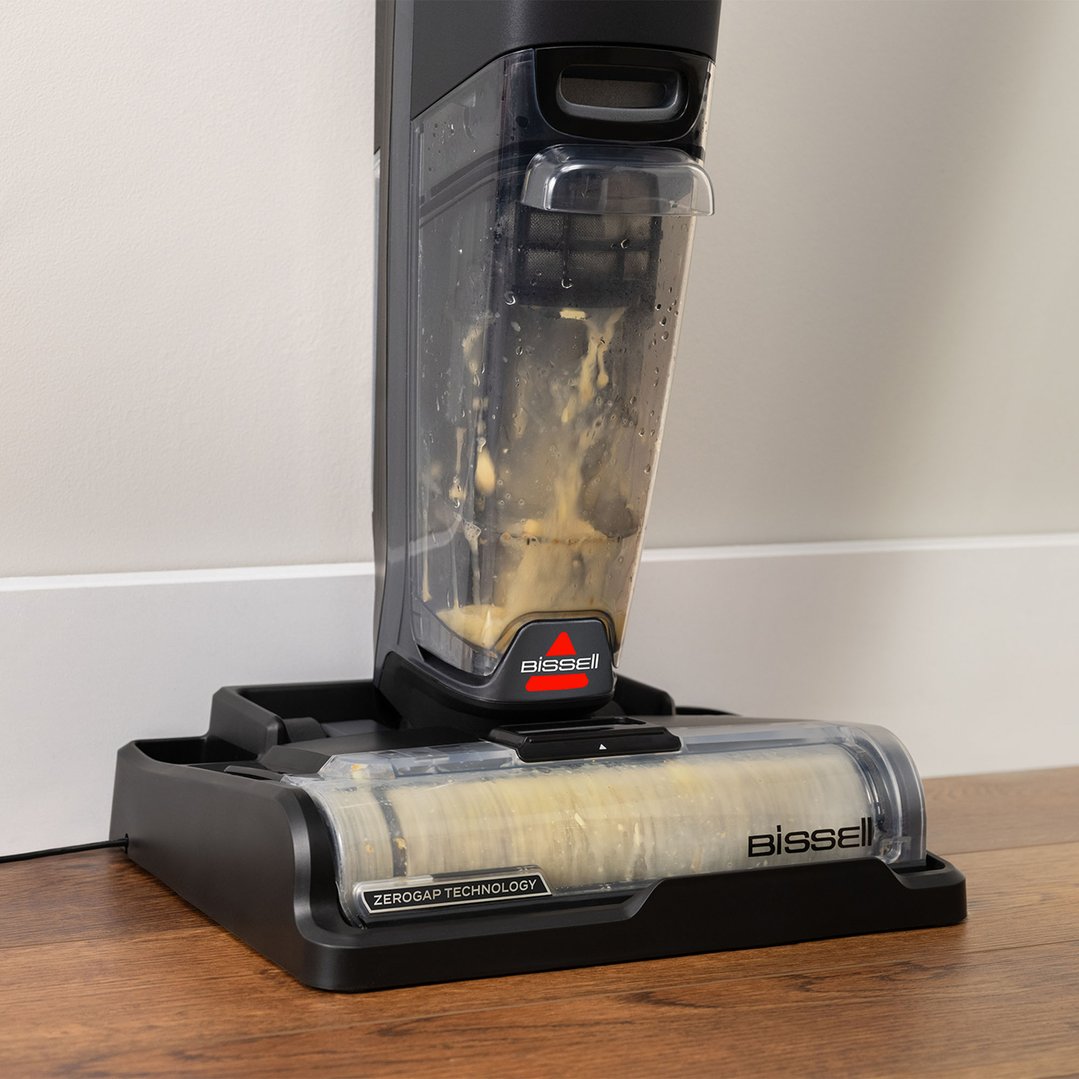 Close-up of a BISSELL vacuum cleaner with dirty water in its tank