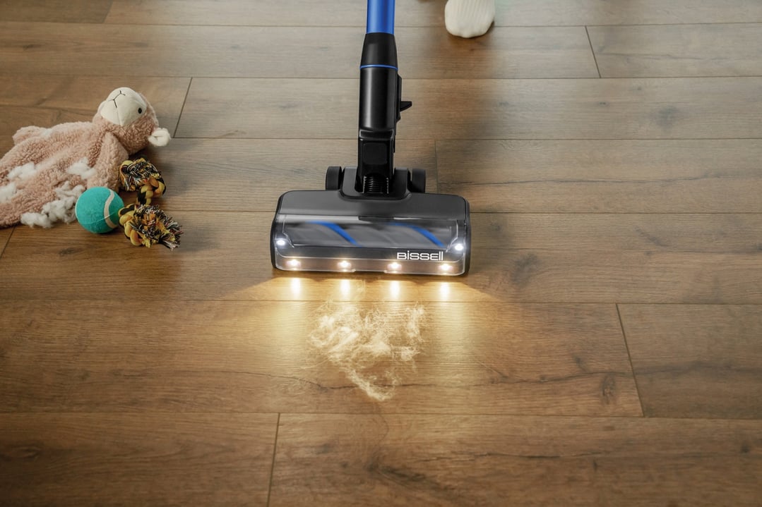 Bissell handstick vacuum cleaning pet hair and debris from a wooden floor