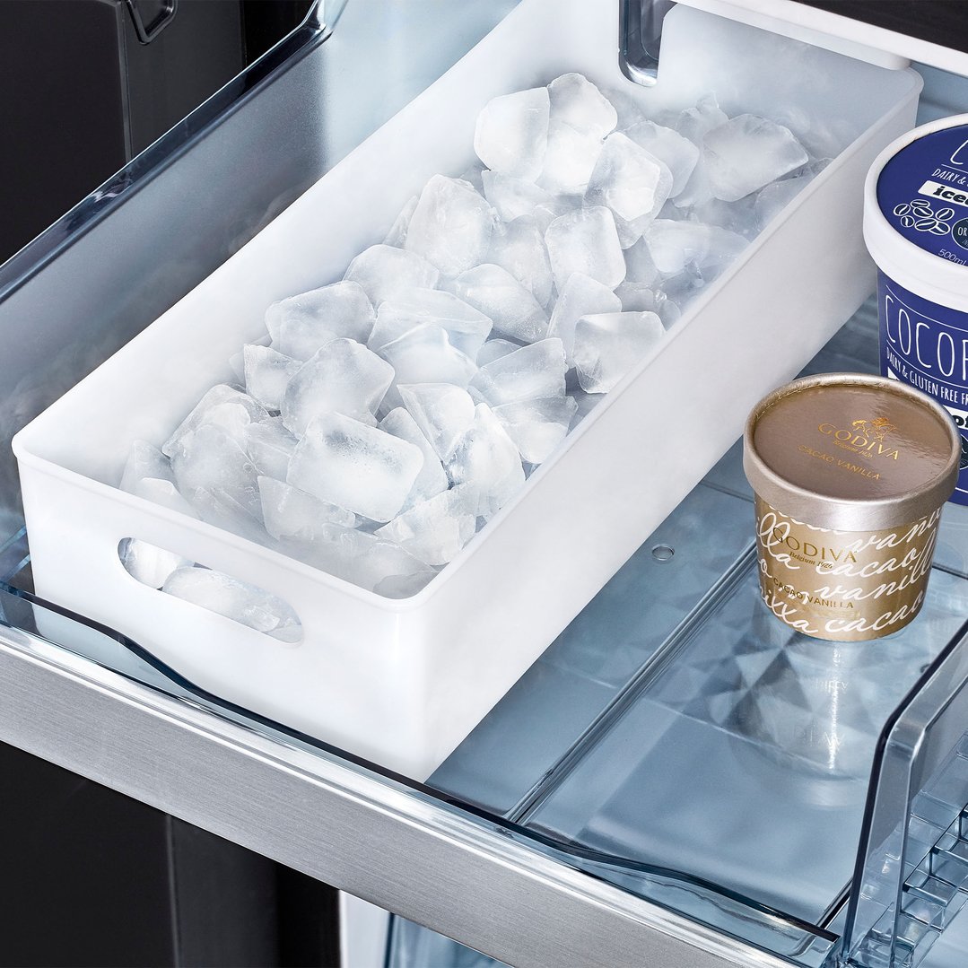Open fridge drawer with ice and two tubs of ice cream