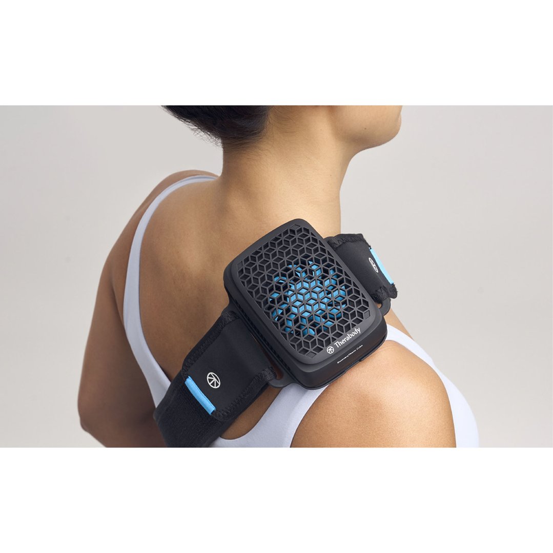 Woman wearing a black and blue massager on her right shoulder