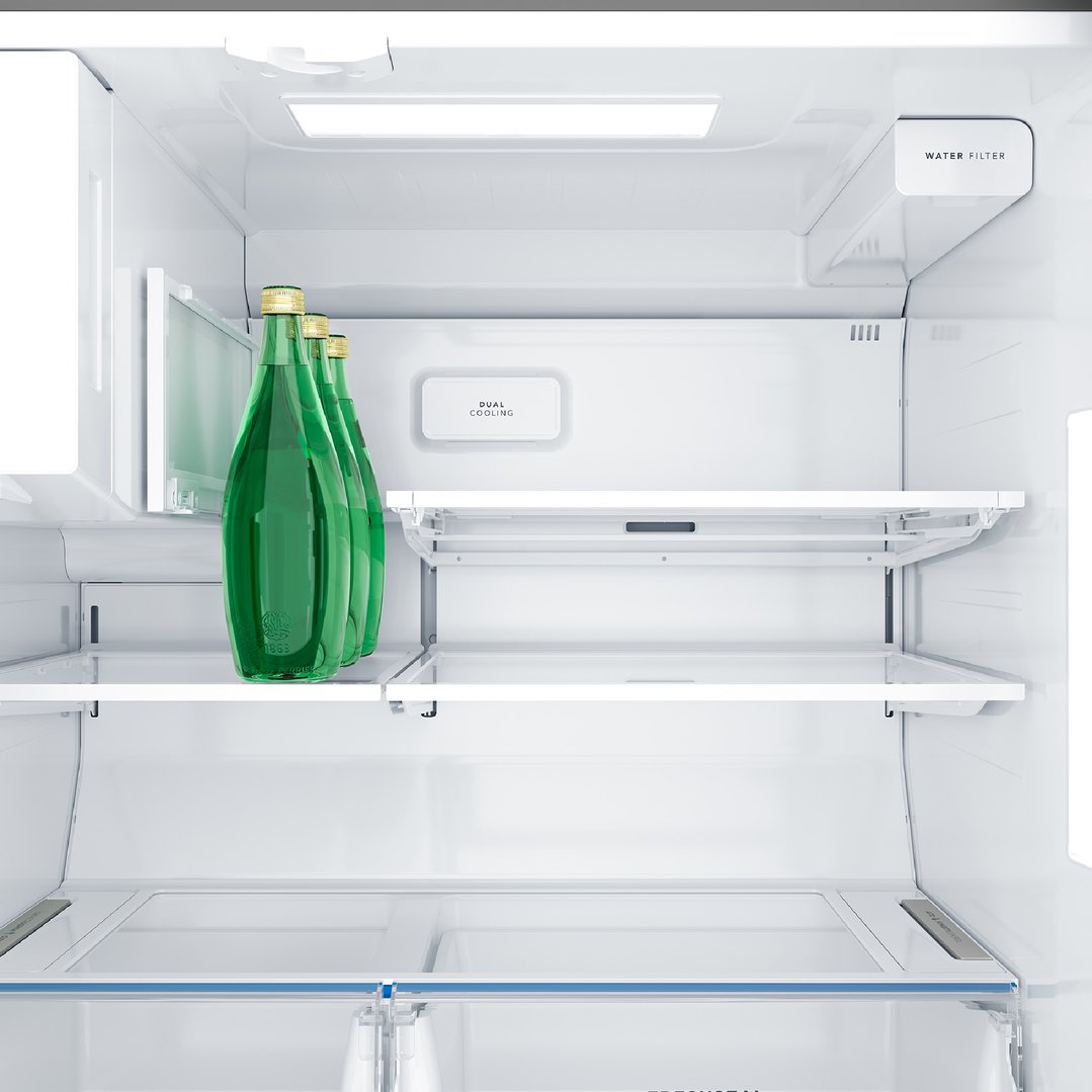 Interior view of a fridge with three green bottles on a shelf