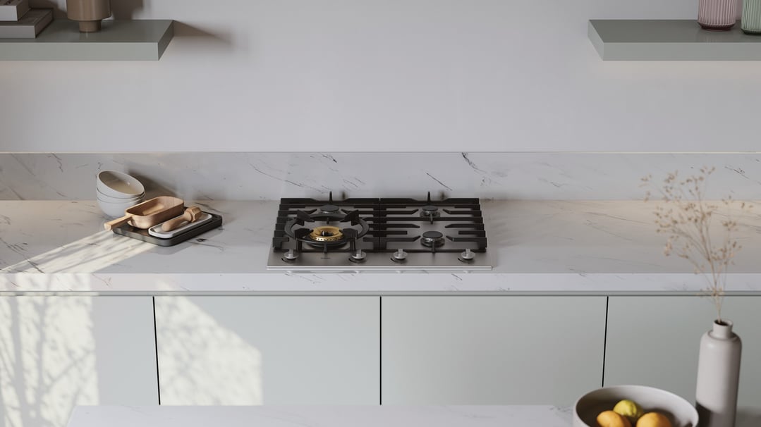 Stainless steel gas cooktop in a modern kitchen with marble countertop