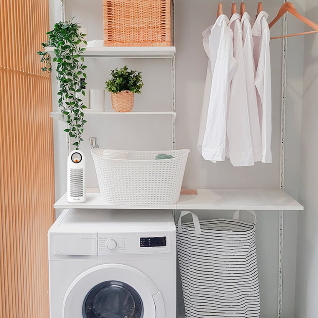 Breville dehumidifier on a shelf above a washing machine in a laundry room