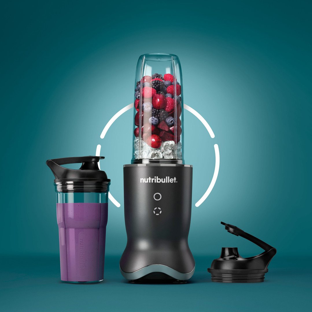 Nutribullet blender with berries and ice, a smoothie cup, and a lid
