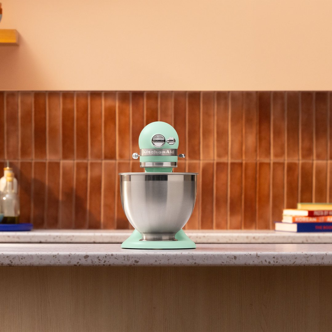 Spearmint KitchenAid stand mixer on a kitchen counter with a tiled backsplash