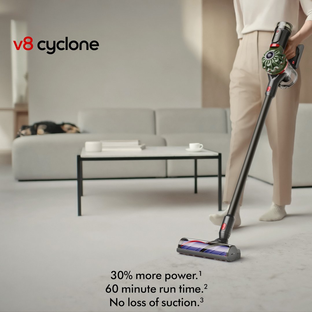 Woman vacuuming a light-colored floor with a Dyson V8 Cyclone cordless vacuum