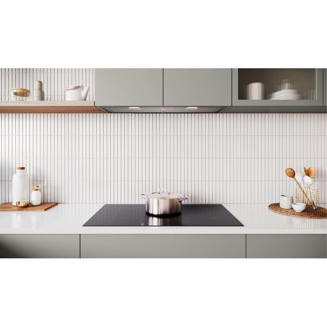 Integrated rangehood above a cooktop with a pot in a modern kitchen
