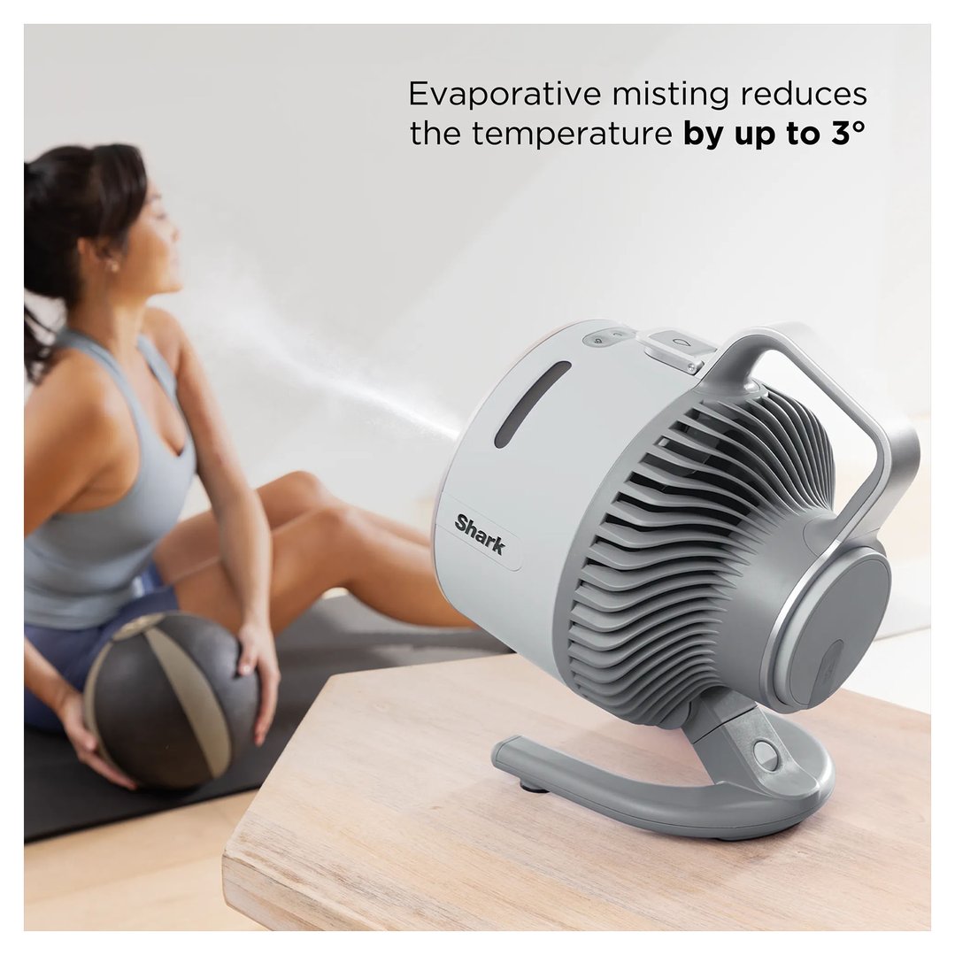 Shark portable fan misting a woman exercising with a medicine ball
