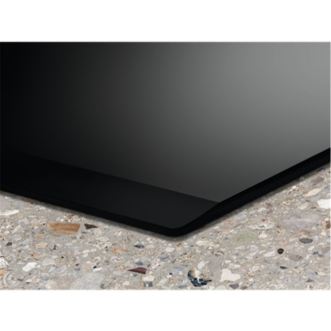 Black induction cooktop installed in a speckled grey countertop