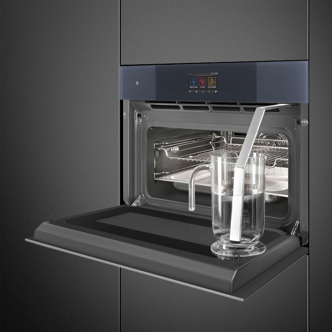 Open compact omnichef oven with a glass measuring cup and water inside
