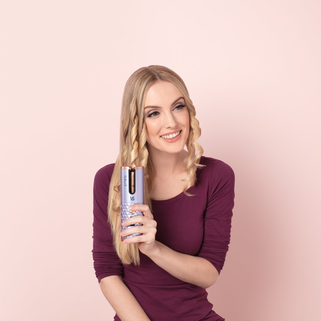 Woman with blonde hair holding a VS Sassoon Unbound Auto Cordless Hair Curler
