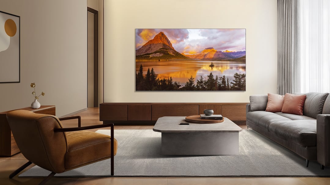 A large TV displaying a mountain lake scene in a modern living room