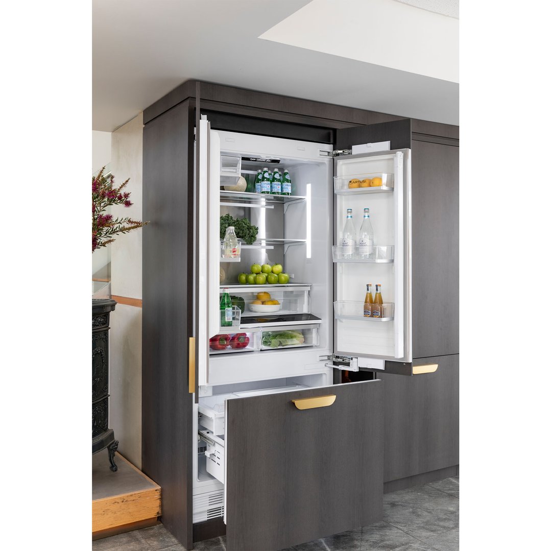 Open integrated French door fridge in a dark wood kitchen cabinet