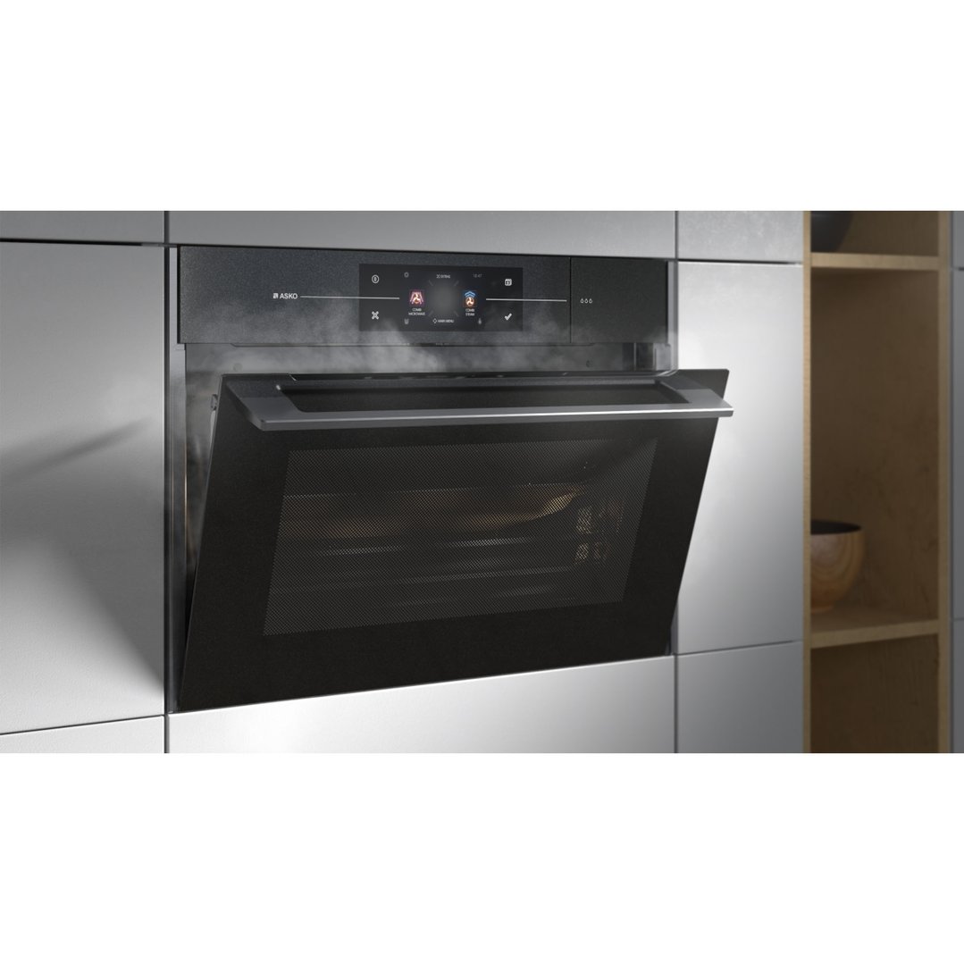 Built-in compact combi-microwave-steam oven with door ajar in a modern kitchen