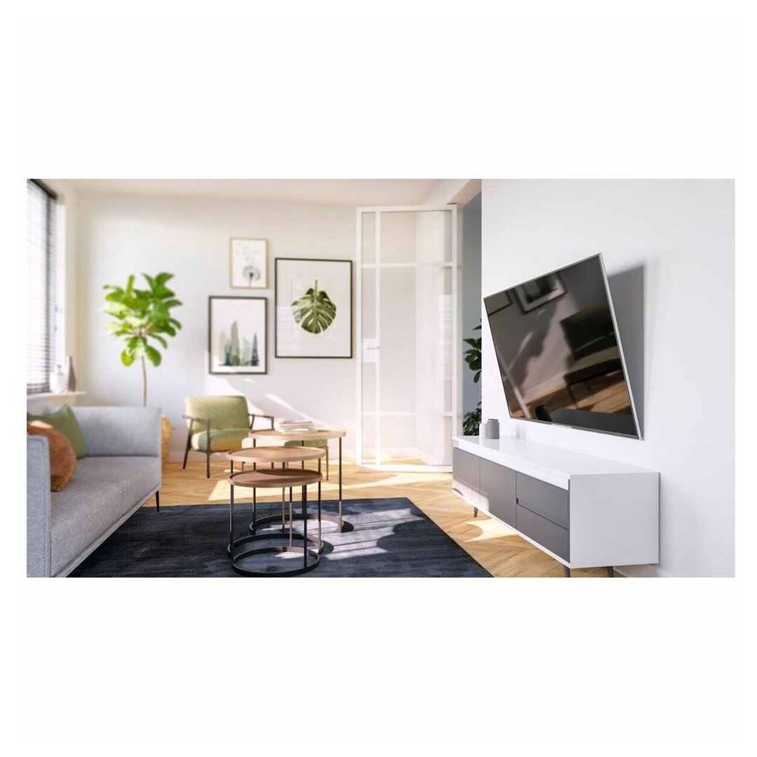 A TV wall mount with a TV mounted on a white wall in a modern living room