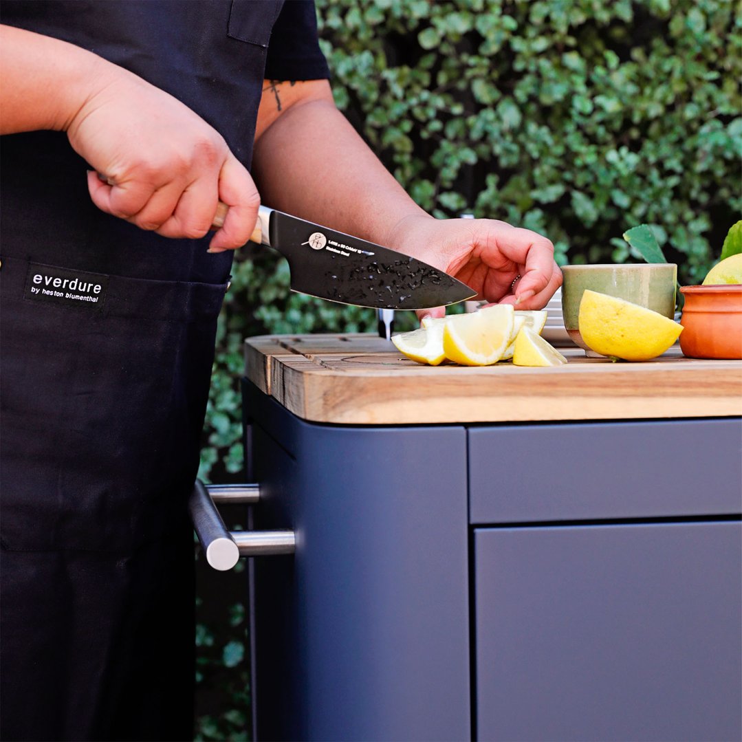 Person cutting lemons on a wooden board of the Mobile Preparation Kitchen