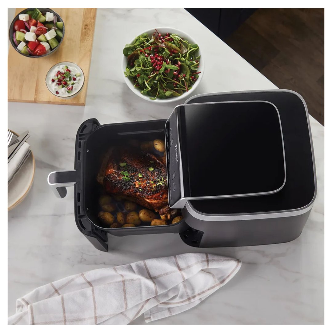 Ninja Air Fryer Pro XL cooking a whole chicken and potatoes on a kitchen counter