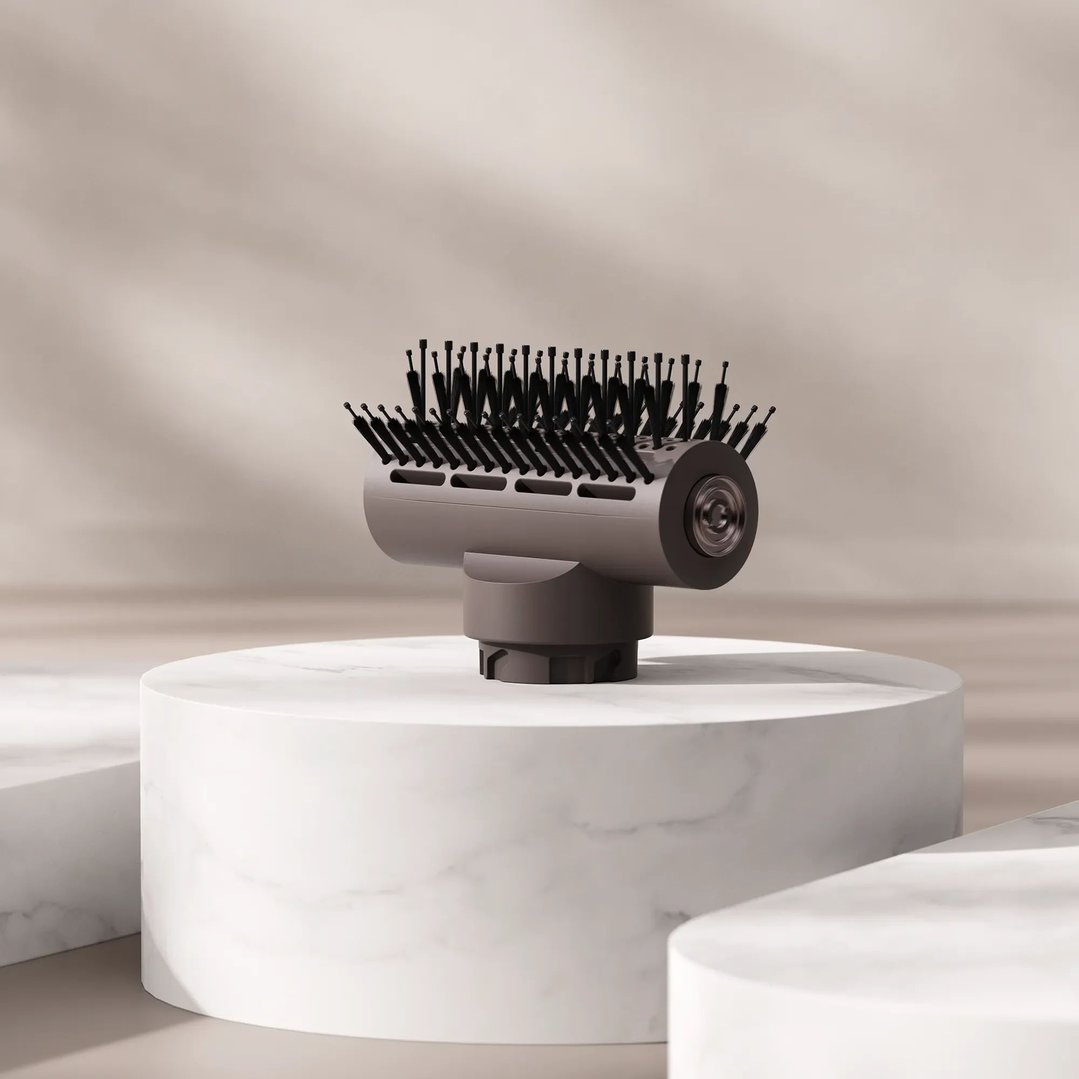 A hair dryer brush attachment on a white marble pedestal