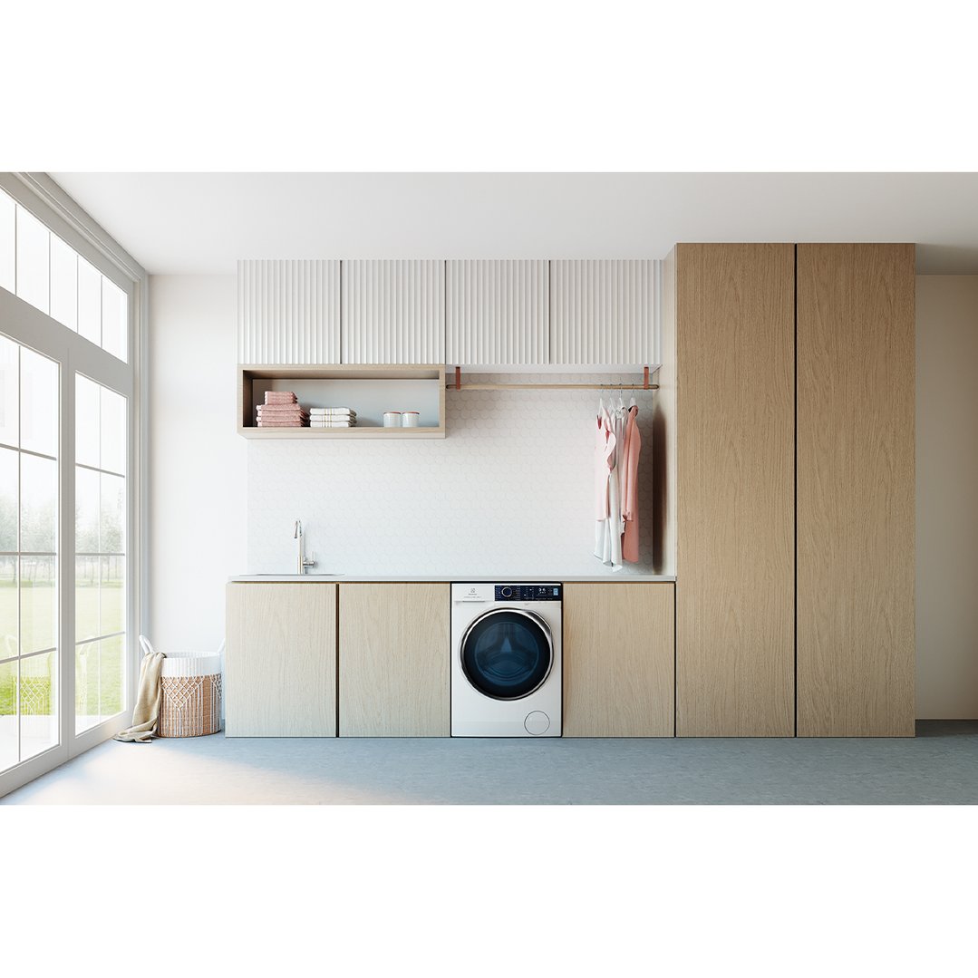White front load washing machine in a modern laundry room with wooden cabinets