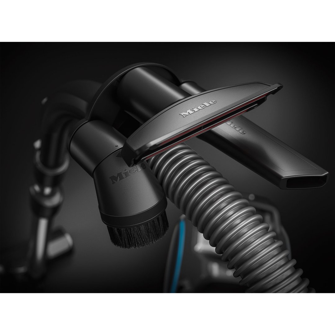 Close-up of vacuum cleaner hose and attachments on a dark background