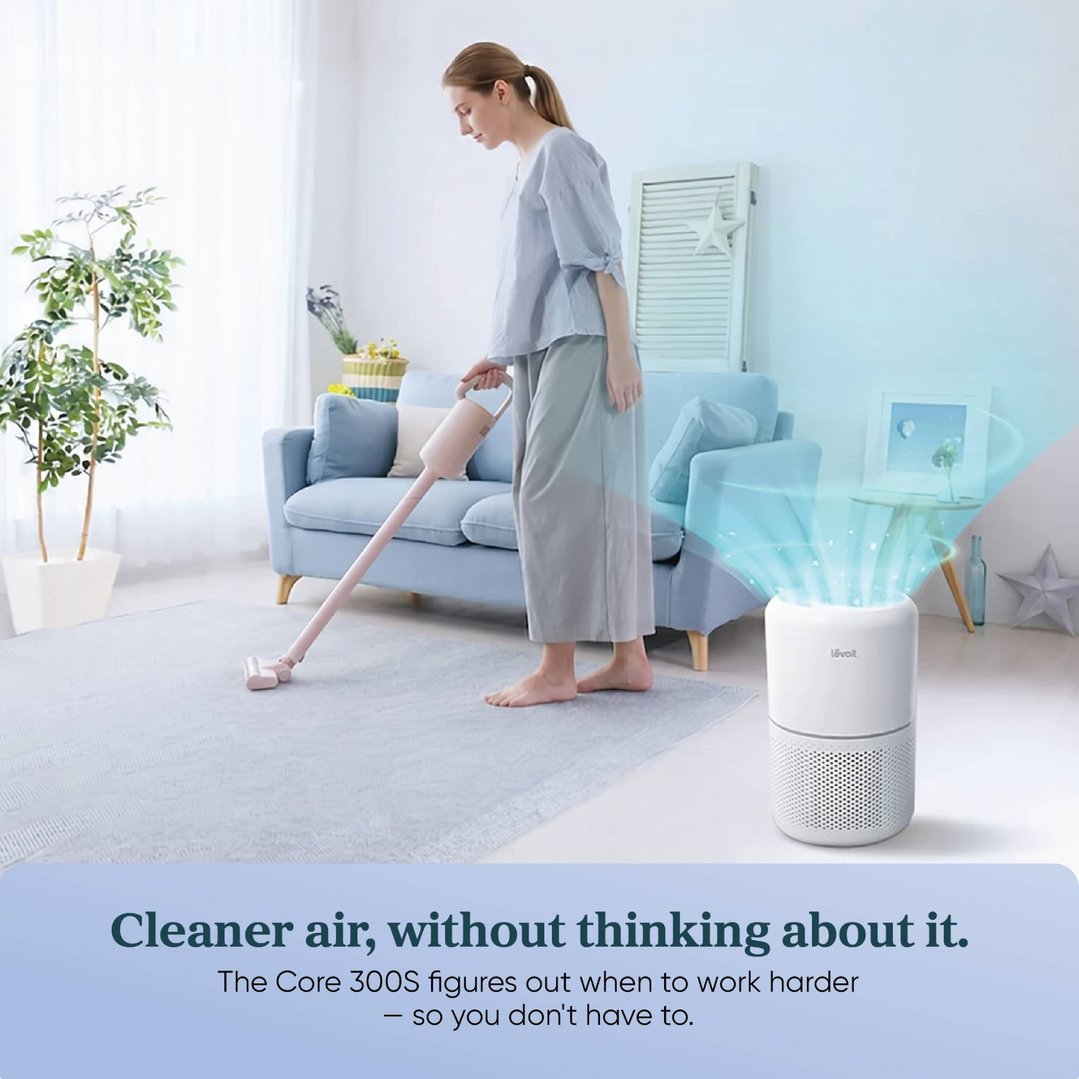 Woman vacuuming a rug in a living room with an air purifier running