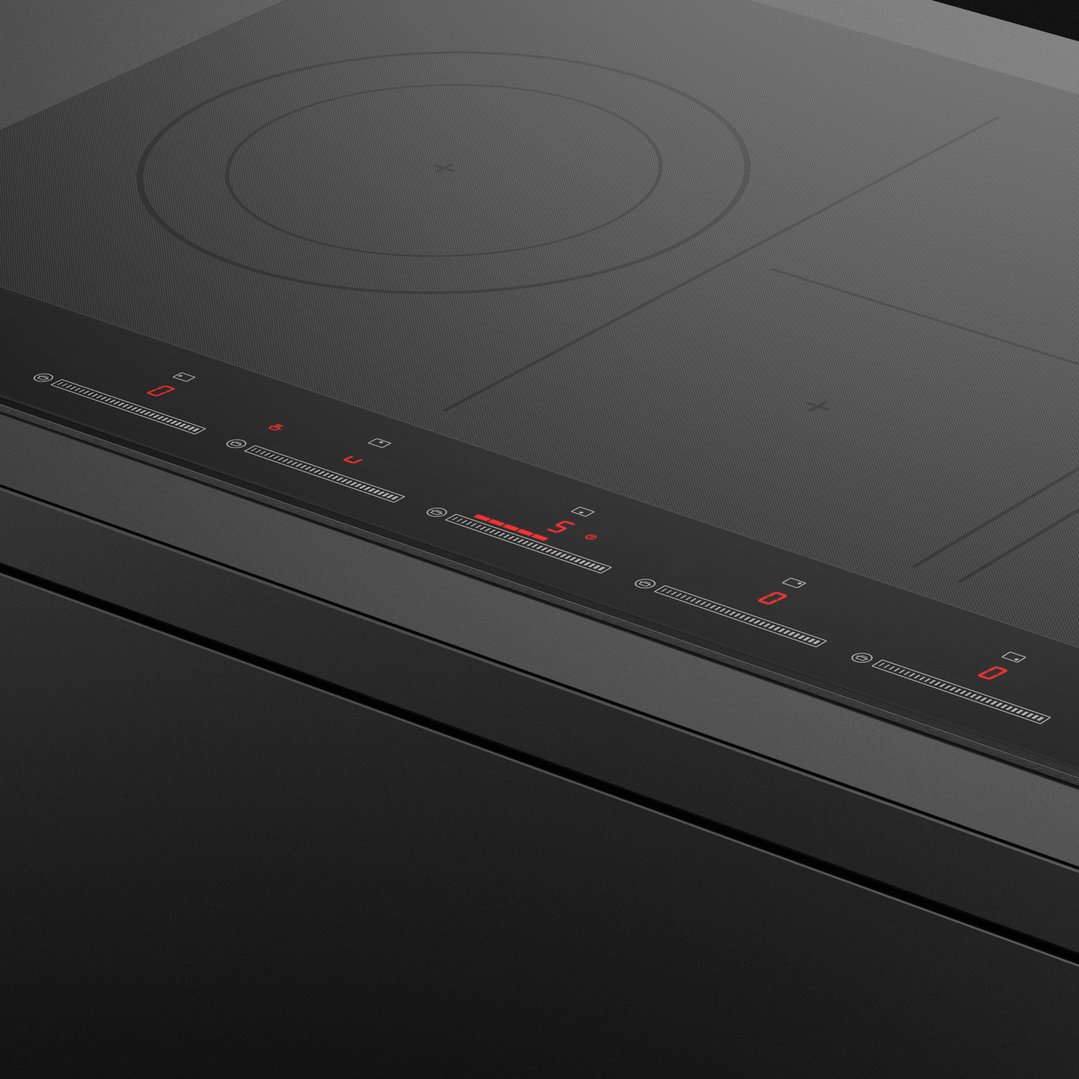 Close up of a black induction cooktop with illuminated red controls