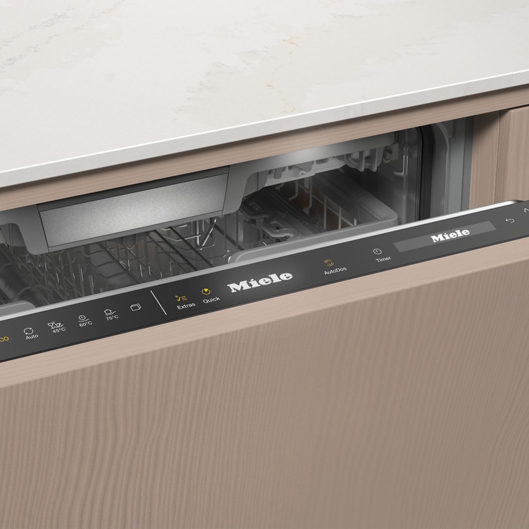Open integrated dishwasher with control panel and racks in a kitchen setting