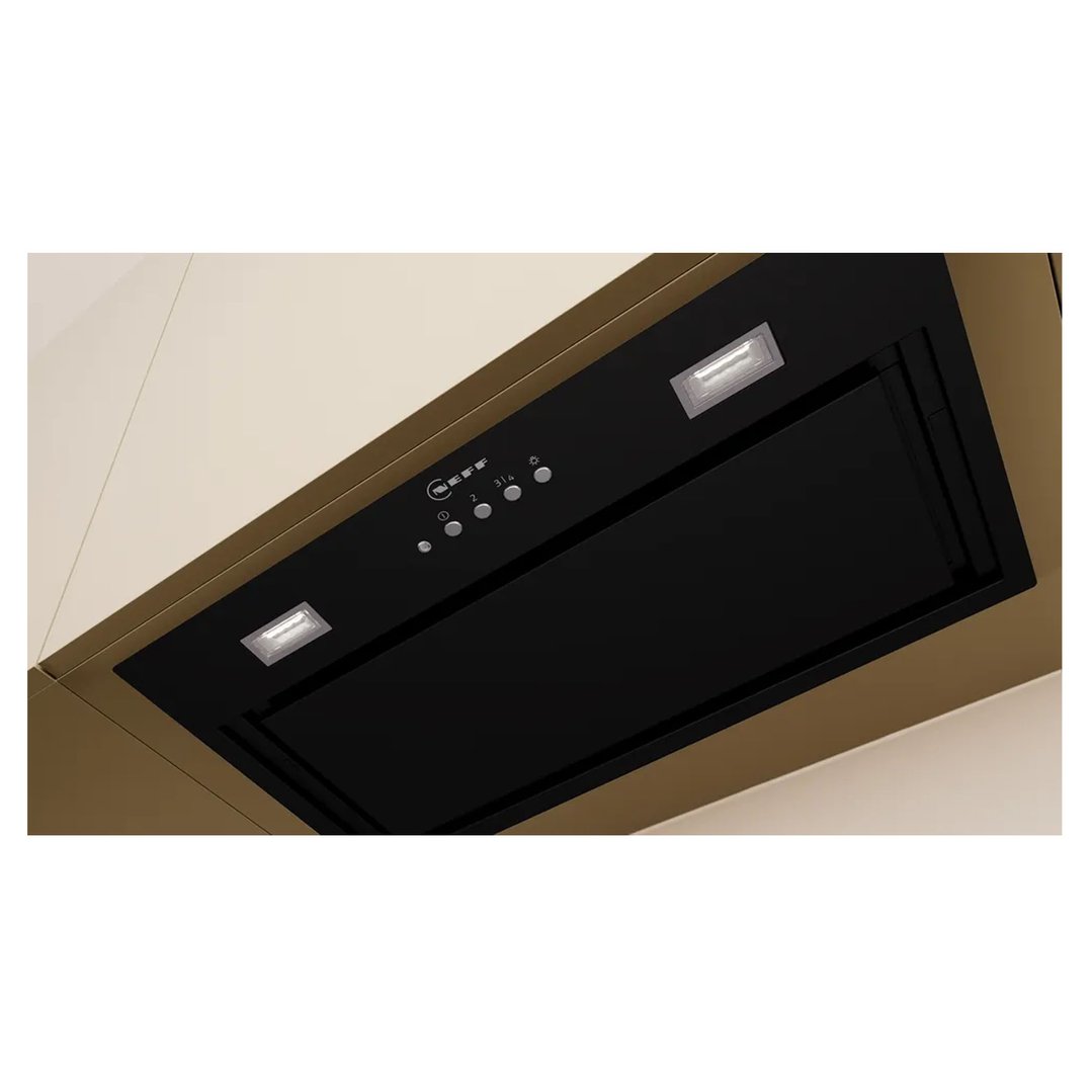 Black integrated rangehood with controls and lights built into a kitchen cabinet