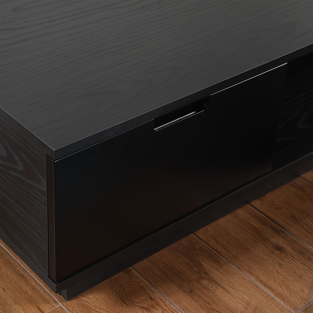 Close up of a black oak TV cabinet on a wooden floor