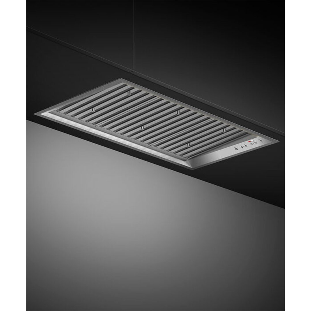 Stainless steel integrated insert rangehood installed in a dark ceiling
