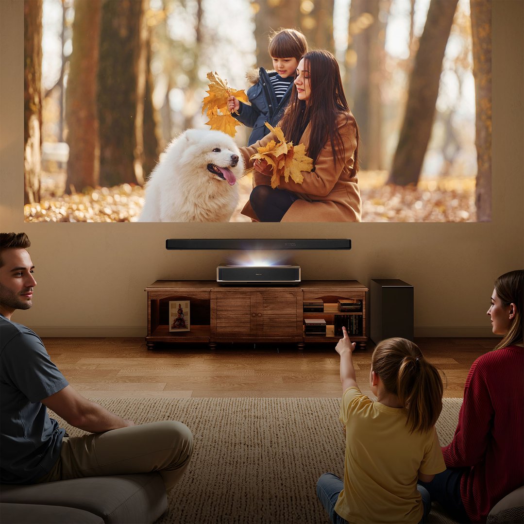 Family watching a movie projected onto a large screen in a living room